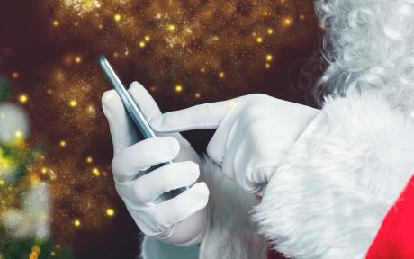 Close up of Santa's hand sending a text message.