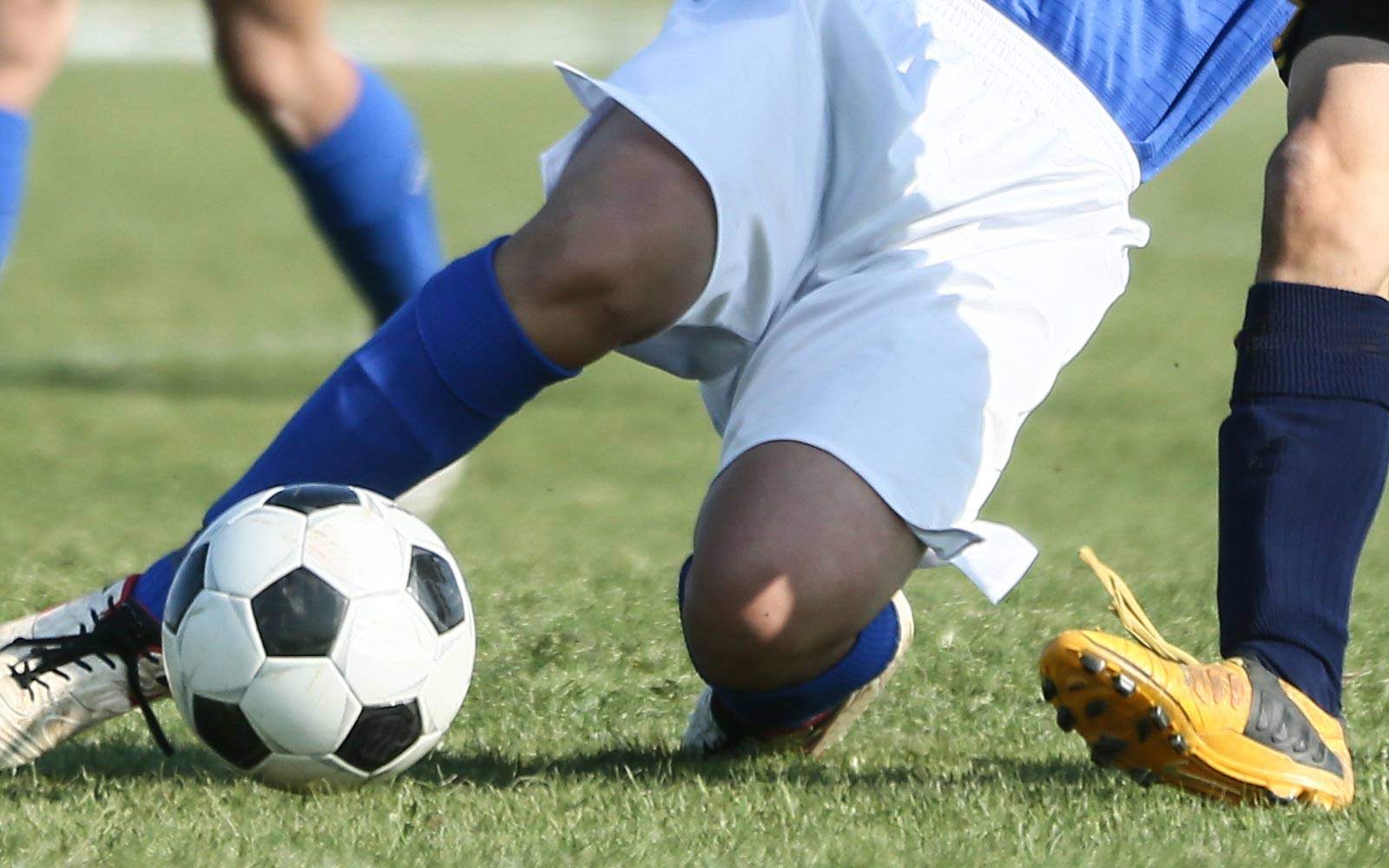 Person sliding to kick a football.