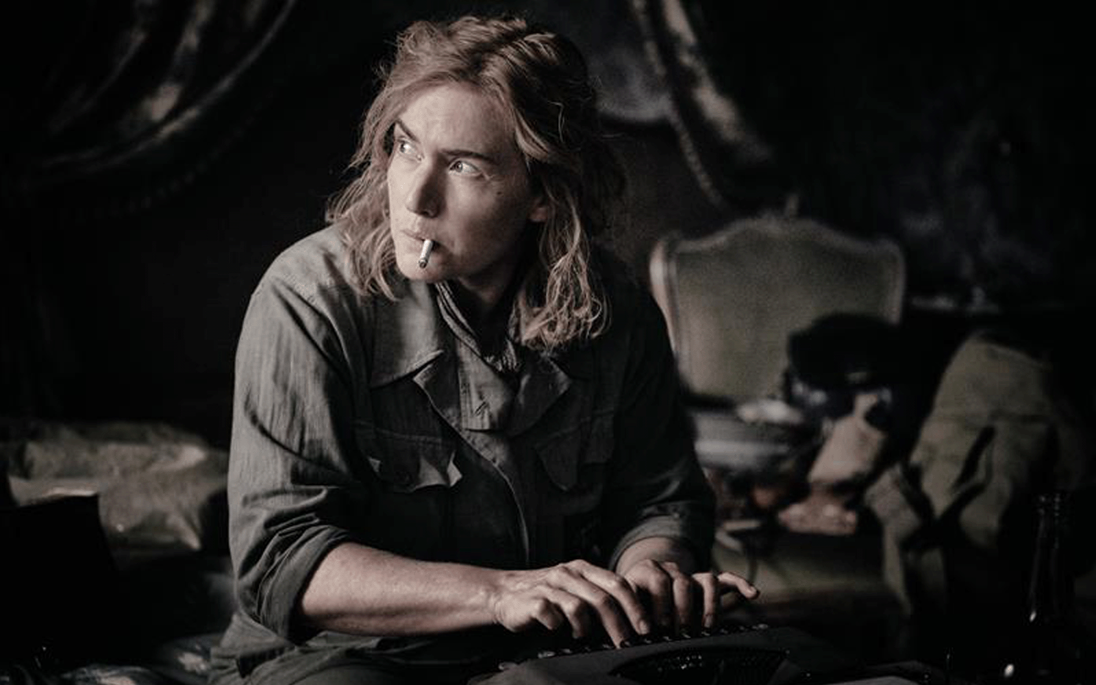 Movie still from the film Lee. Kate Winslet looking at from the camera, smoking a cigarette. 