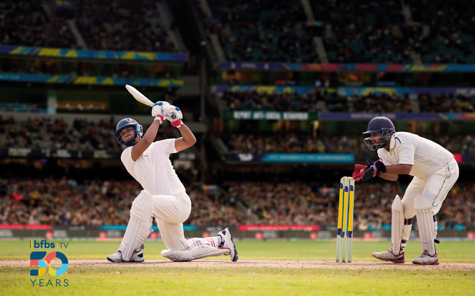 Action shot of a cricket player mid swing.