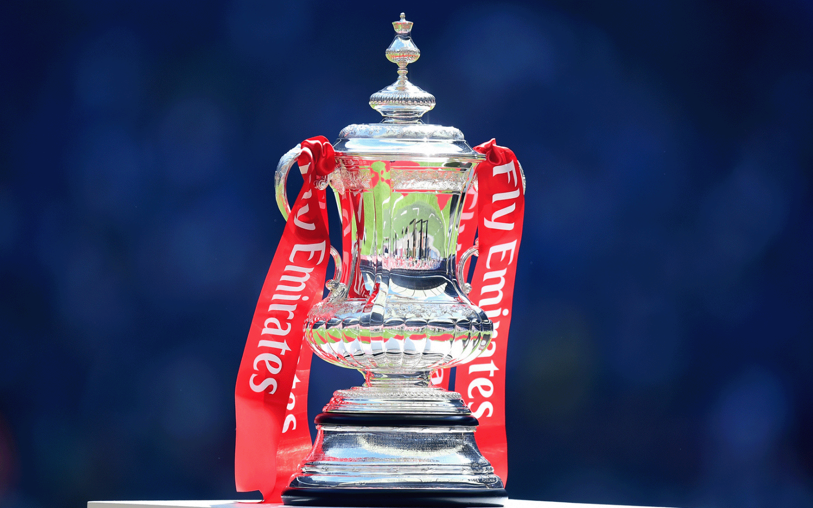 A photo of the FA Cup, with a dark blue background.