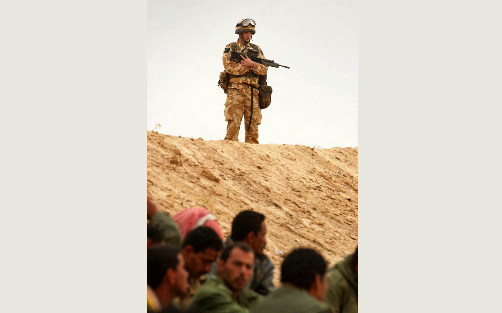 Image of a soldier on a high ground, crowd of people below.