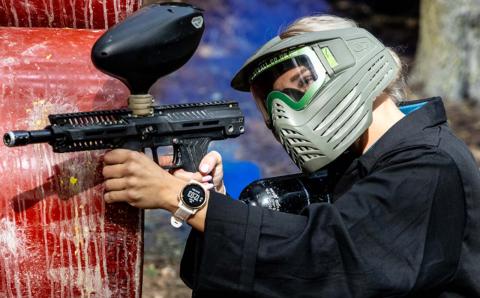 Close up of person holding a paintball gun.
