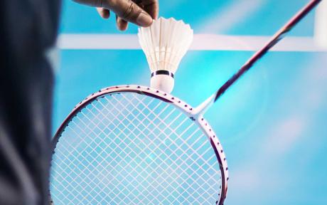 Person about to serve in badminton match.