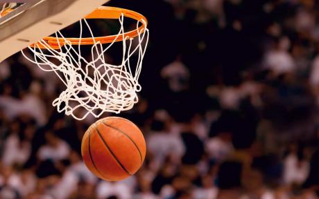 Basketball heading towards a basketball net.