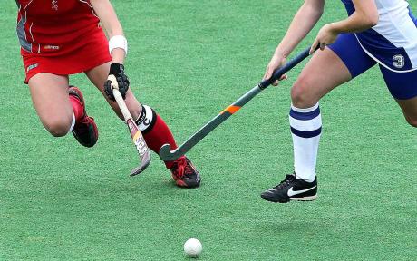 Close up of two hockey players challenging for the ball.