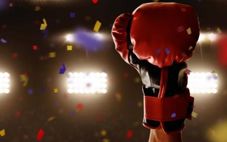 Close up of a boxing glove in the air mid-celebration.