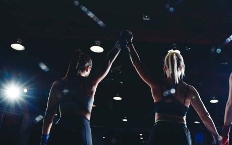 Woman's hand being raised in victory after an mma fight.