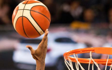Basketball heading towards a basketball net.