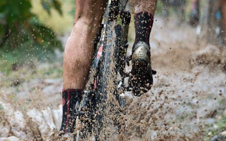 Close up of someone using a mountain bike in rough terrain. 