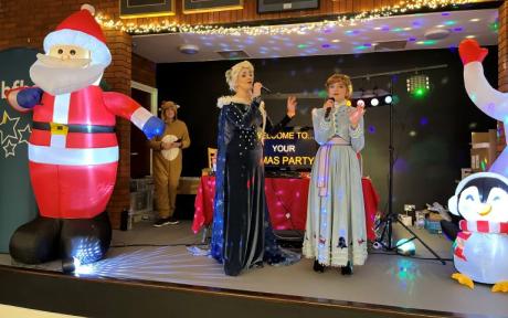 Two women on a stage in Frozen costumes
