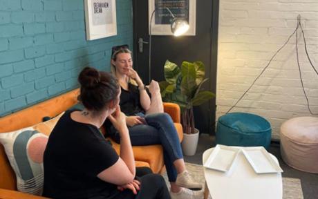 Two people chatting, working in a relaxed office space.