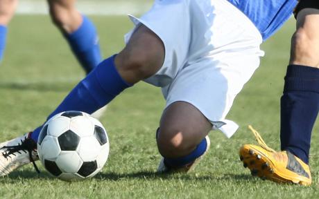 Person sliding to kick a football.
