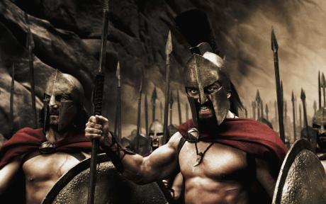 Movie still from the film 300. Close up of Spartan army holding spears and shields.