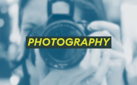 Dutoned close up image of someone holding a camera. Text 'Photography'.