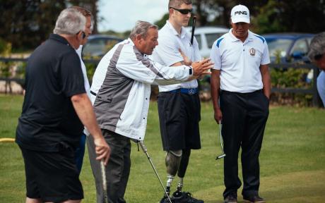 Group of people on a golf course mid-game.