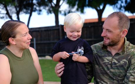 Image of a happy and smiley forces family - two parent and a child.