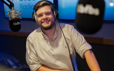 PR photo of Karl Lambert, Army Veteran and BFBS Social Media Manager, in a radio studio.