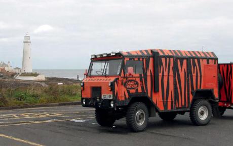 Photo of a truck in-front of a lighthouse.
